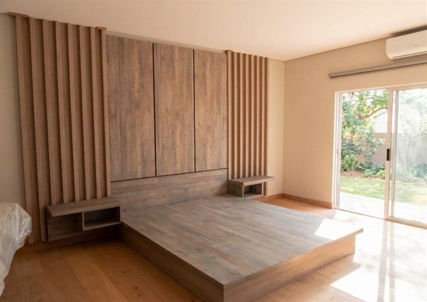 Wall-to-wall feature headboard with slatted panels, wardrobe doors, and floating nightstands &mdash; Wito Projects Johannesburg