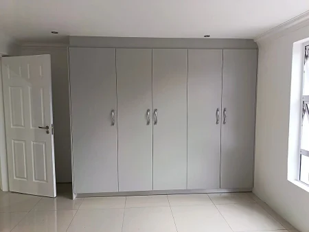 Bryanston kids bedroom: wide view of built-in storage and organised joinery