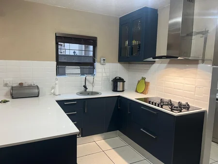 Article hero: petrol blue Fourways kitchen with white quartz and subway tile