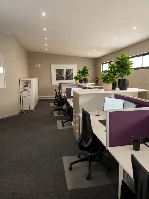 Open-plan office with white workstations, purple acoustic dividers, and planter-lined desk layout — Reach for a Dream, Rosebank Johannesburg