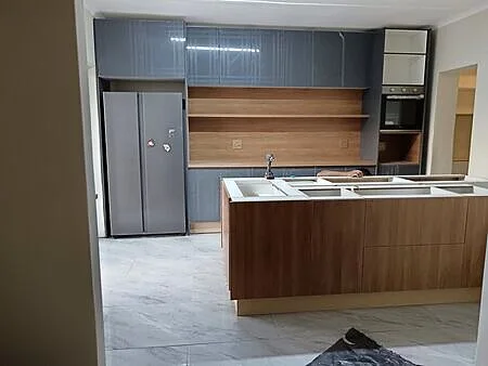 Installer finishing two-tone kitchen cabinetry on site, Roodepoort